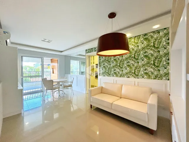 Sala de estar com paredes brancas e destaque verde na decoração.