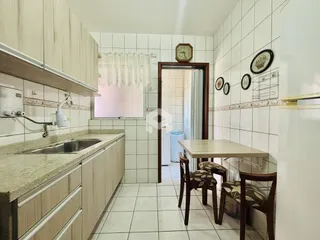 Cozinha com armários e bancada em um imóvel em Lajeado.