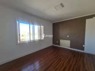 Sala de estar com piso de madeira e grande janela.