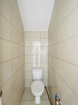 Foto de um banheiro com paredes revestidas de azulejos brancos.