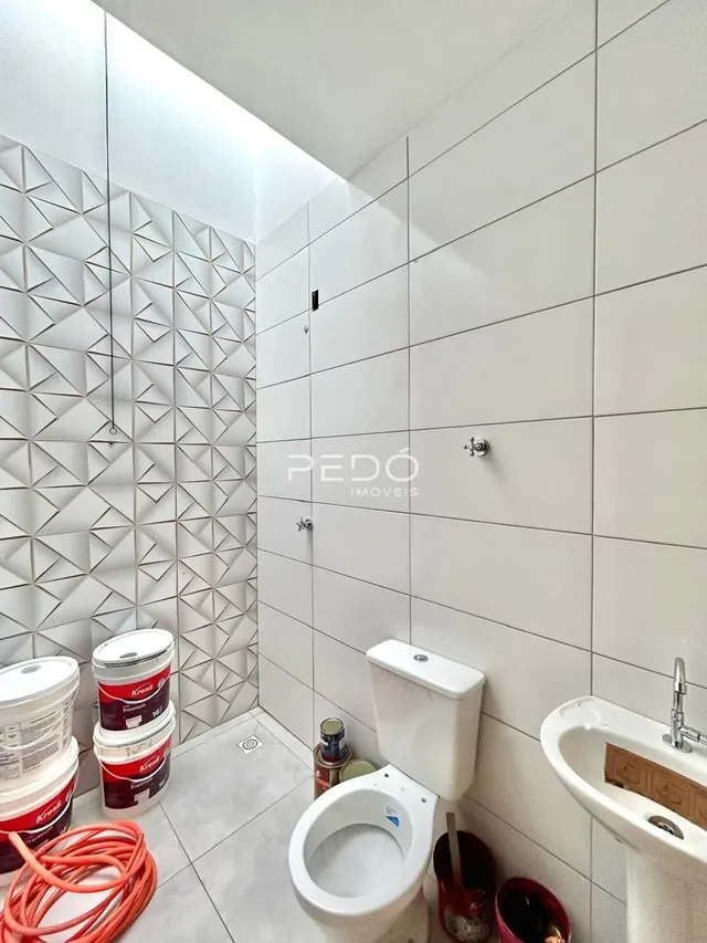 Foto de um banheiro com revestimento de azulejos brancos.