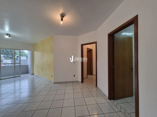 Interior de uma sala com piso de cerâmica e paredes brancas.