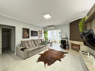 Sala de estar com sofá e lareira em um apartamento.