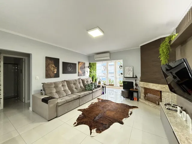 Sala de estar com sofá e lareira em um apartamento.
