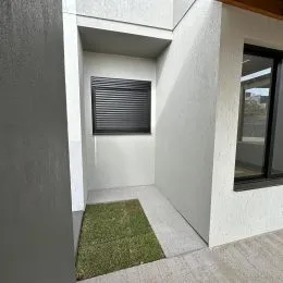 Hall de passagem interna com paredes brancas e piso claro.