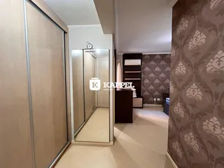 Um corredor interno com armários e decoração de parede em um imóvel.