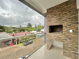 Vista de um ambiente interno com parede de pedra e vista para a rua.