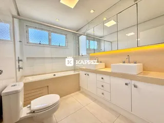 Banheiro moderno com bancada e box de vidro.