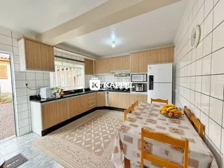 Foto de uma cozinha com armários de madeira e mesa de jantar.