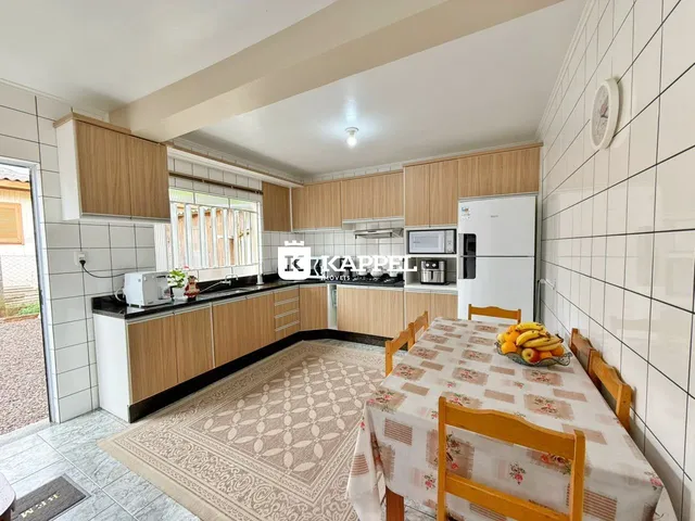 Foto de uma cozinha com armários de madeira e mesa de jantar.