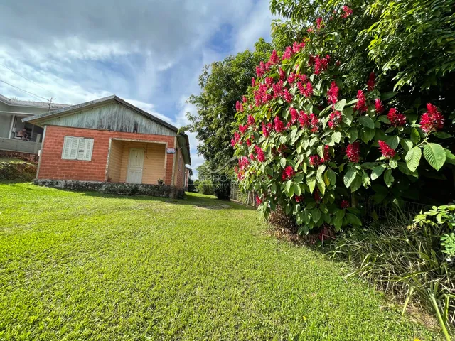 Vista externa de uma residência em Lajeado com gramado verde e vegetação exuberante.