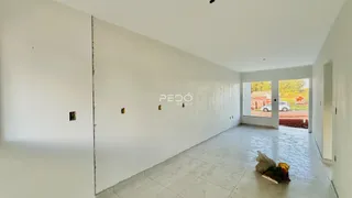 Interior de um espaço amplo com paredes brancas e piso de cerâmica.