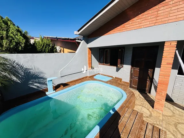 Vista externa de uma área de piscina com deck de madeira.