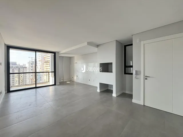 Ambiente interno moderno com grandes portas de vidro e vista da cidade.
