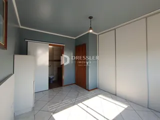 Interior de um ambiente com paredes azuis claras e piso de cerâmica.