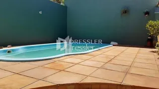 Piscina externa com deck de cerâmica em uma propriedade.