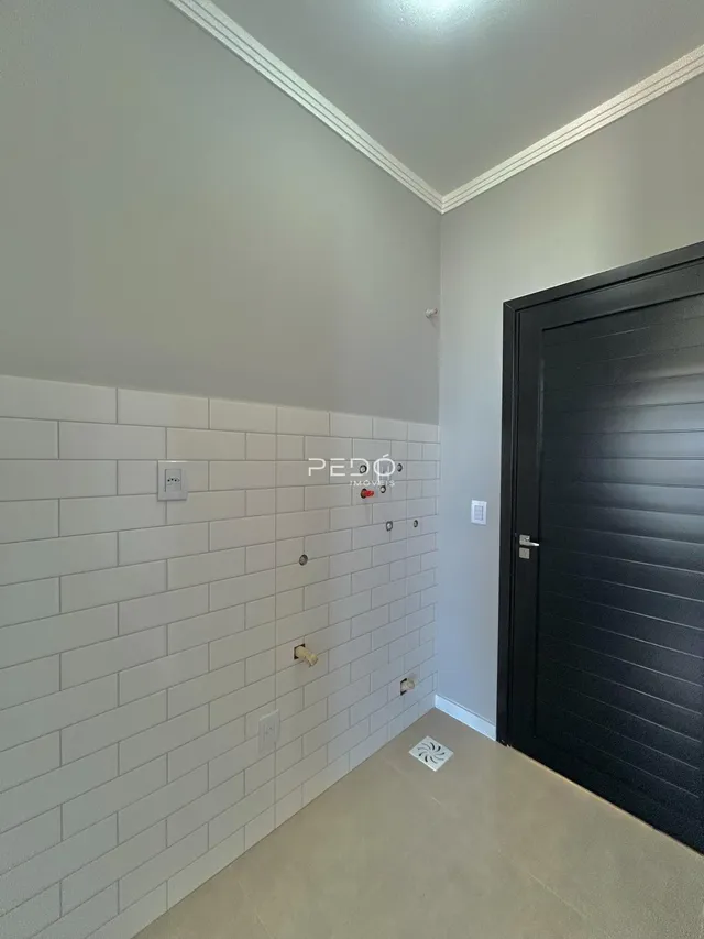Parede com revestimento de azulejos brancos em um ambiente residencial.