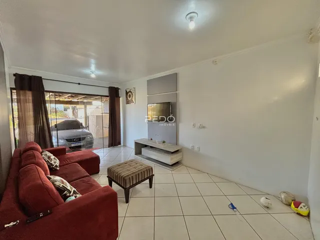 Sala de estar com sofá vermelho e piso de cerâmica claro.