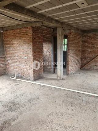 Parede de tijolos aparentes e estrutura de concreto de uma edificação.