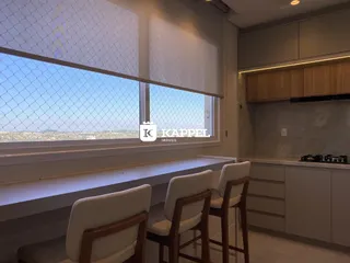 Vista de uma cozinha moderna com bancada e assentos em um ambiente interno.
