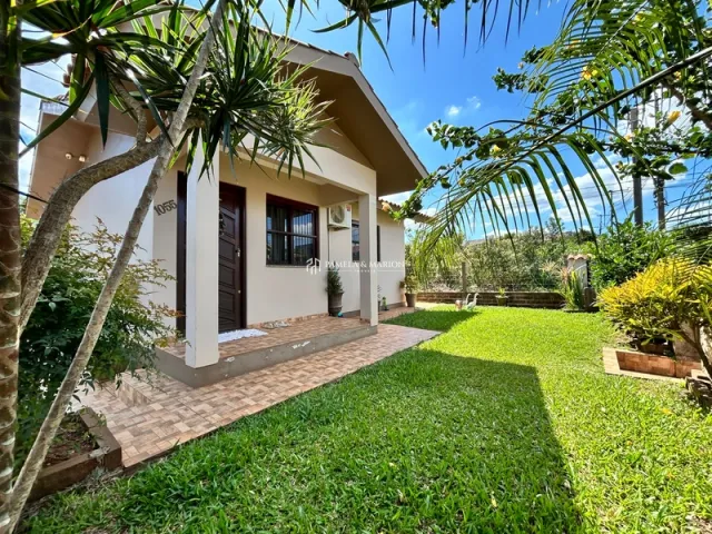 Fachada de uma casa em Lajeado, Brasil, com gramado e vegetação tropical.