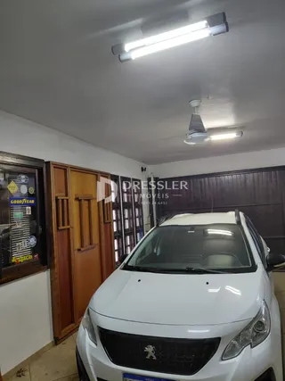 Foto de um cômodo interno com paredes brancas e portas de madeira.