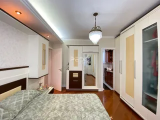 Quarto com armários brancos e piso de madeira no interior da residência.