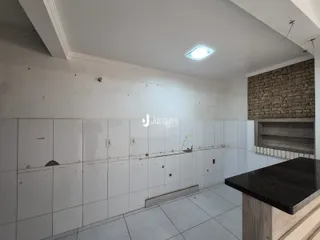 Interior de uma área com paredes brancas e piso de cerâmica.