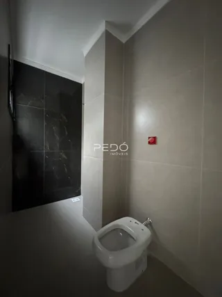 Foto de um banheiro interno com vaso sanitário branco e paredes claras.