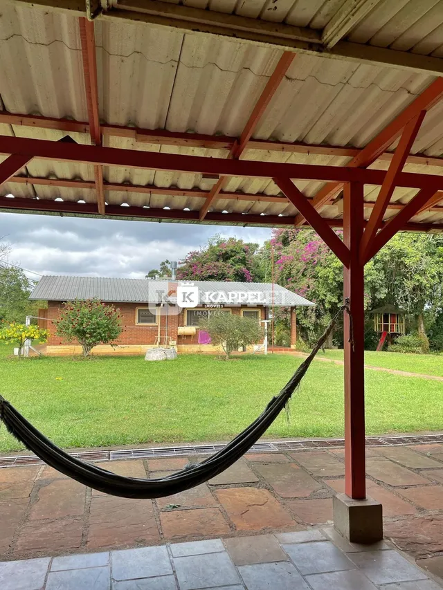 Foto da fachada de uma casa com telhado de metal e gramado verde.