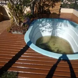 Foto de uma piscina externa com deck de madeira em uma propriedade.
