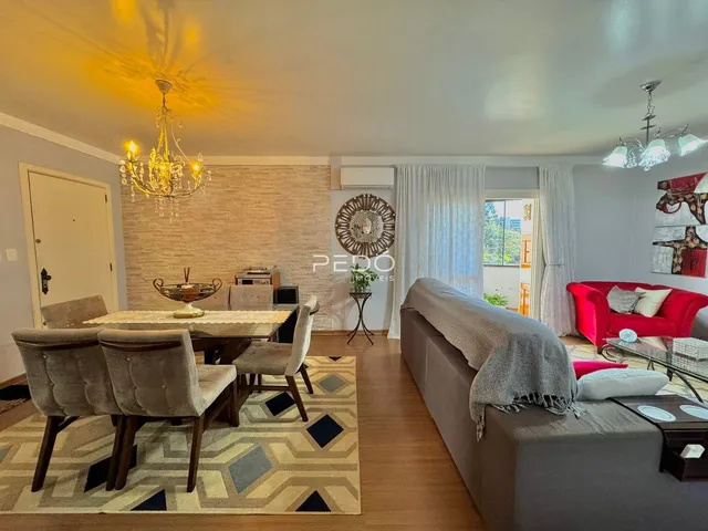Sala de estar e jantar com piso de madeira e sofá cinza.