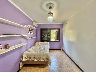 Quarto com paredes roxas e estantes brancas em um imóvel no Brasil.