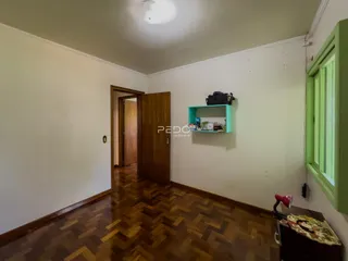 Hall de entrada com piso de madeira e parede branca.