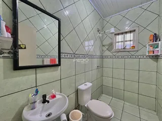 Banheiro com revestimento de cerâmica e louças sanitárias.