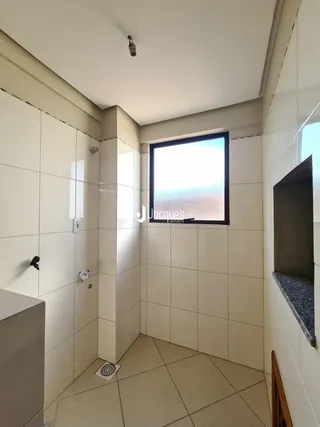 Vista de um corredor interno com piso e paredes revestidos de cerâmica.