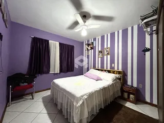 Quarto com paredes roxas e cama de dossel em um imóvel no Brasil.