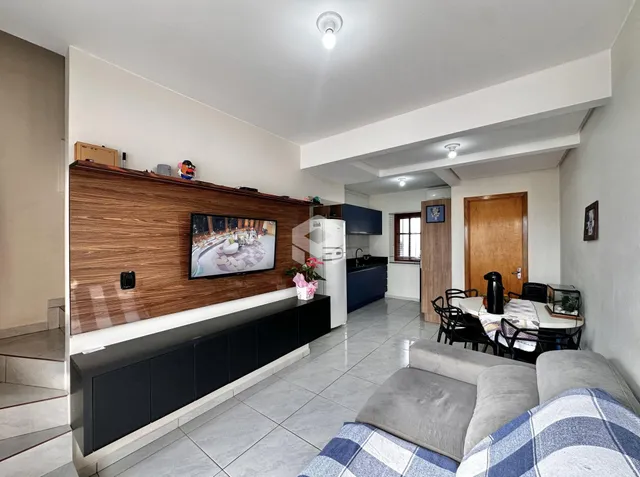 Sala de estar com parede de TV e sofá em um apartamento no Brasil.