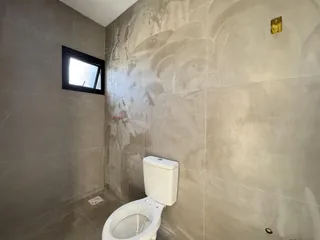 Foto de um banheiro com paredes revestidas em azulejos claros.