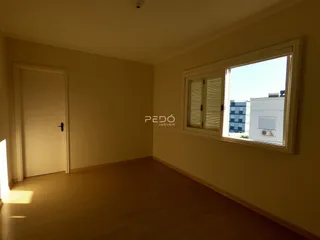 Ambiente interno de uma sala com piso de madeira e janela em um imóvel em Lajeado.