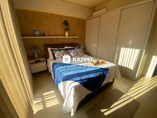 Quarto com cama e armários brancos em um ambiente bem iluminado.