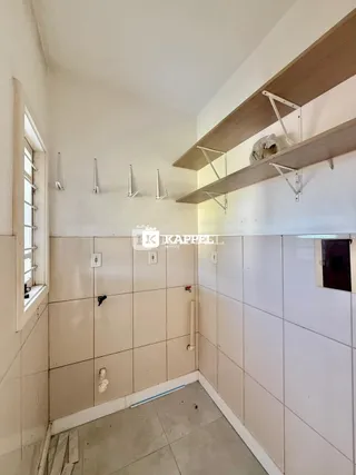 Corredor interno com paredes revestidas de azulejos claros e prateleiras de madeira.
