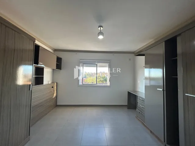 Interior de uma sala de estar com piso de cerâmica e armários embutidos.