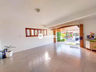 Sala de estar ampla com piso de cerâmica e acesso a uma área externa coberta.
