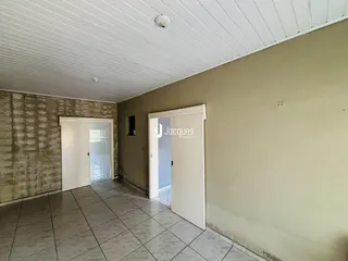 Hall de entrada com piso de cerâmica e paredes bege.