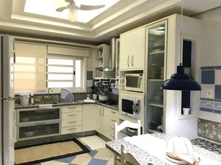 Interior da cozinha com armários brancos e janela.