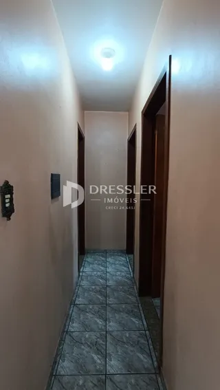 Corredor interno de uma residência com piso de azulejo.