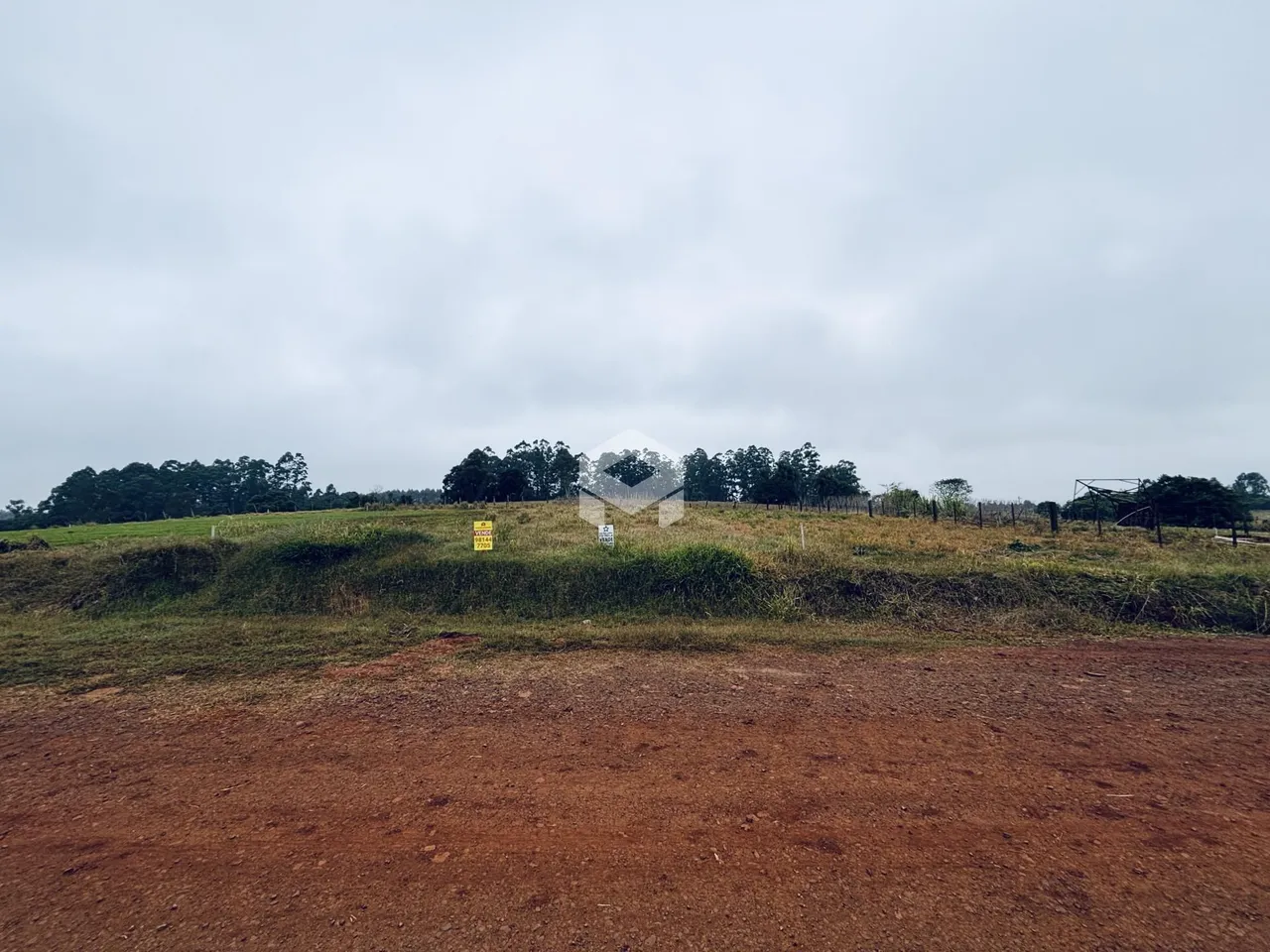 Vista de uma área de campo gramado com vegetação e sinais em Lajeado.