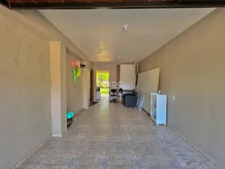 Corredor interno de uma residência com piso de cerâmica.