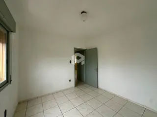 Interior de uma sala com piso de cerâmica e paredes brancas.